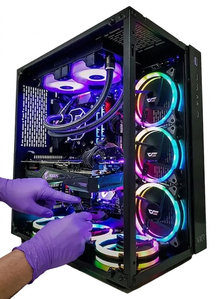 Técnico con guantes trabajando dentro de una computadora de escritorio gamer con iluminación RGB